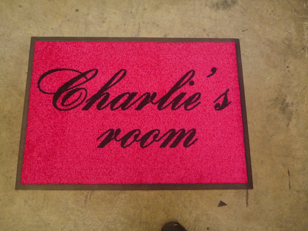 Pink bedroom doormat reading Charlie’s room