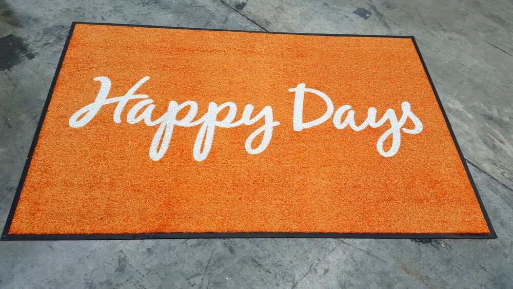 Orange Happy Days doormat with white script