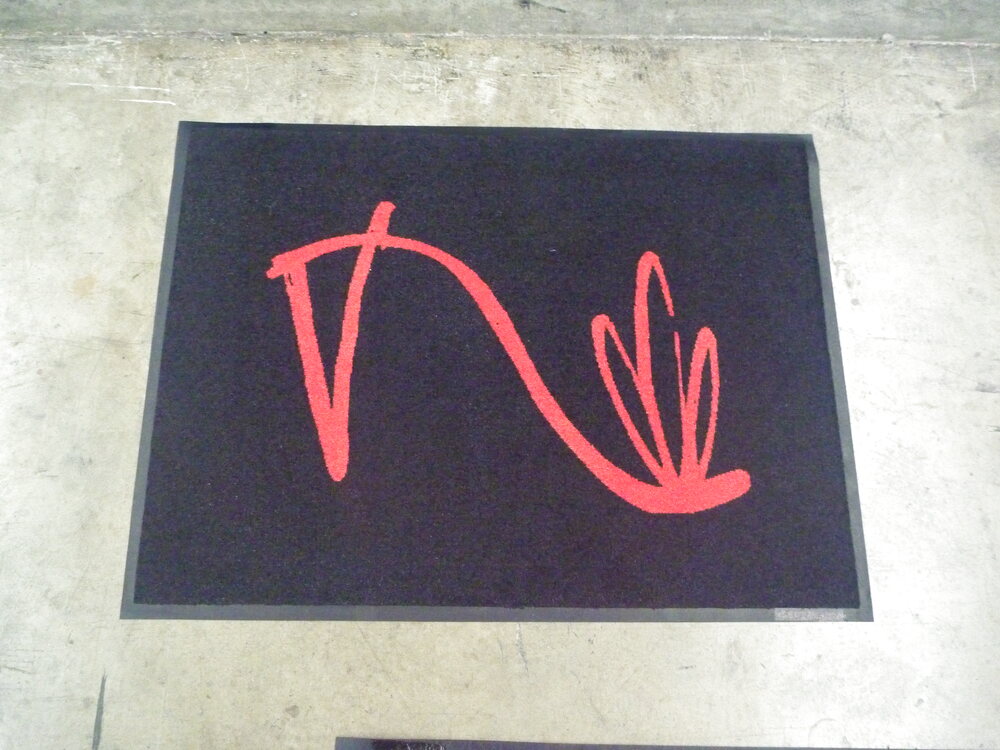 Black doormat with a red line-art stiletto shoe