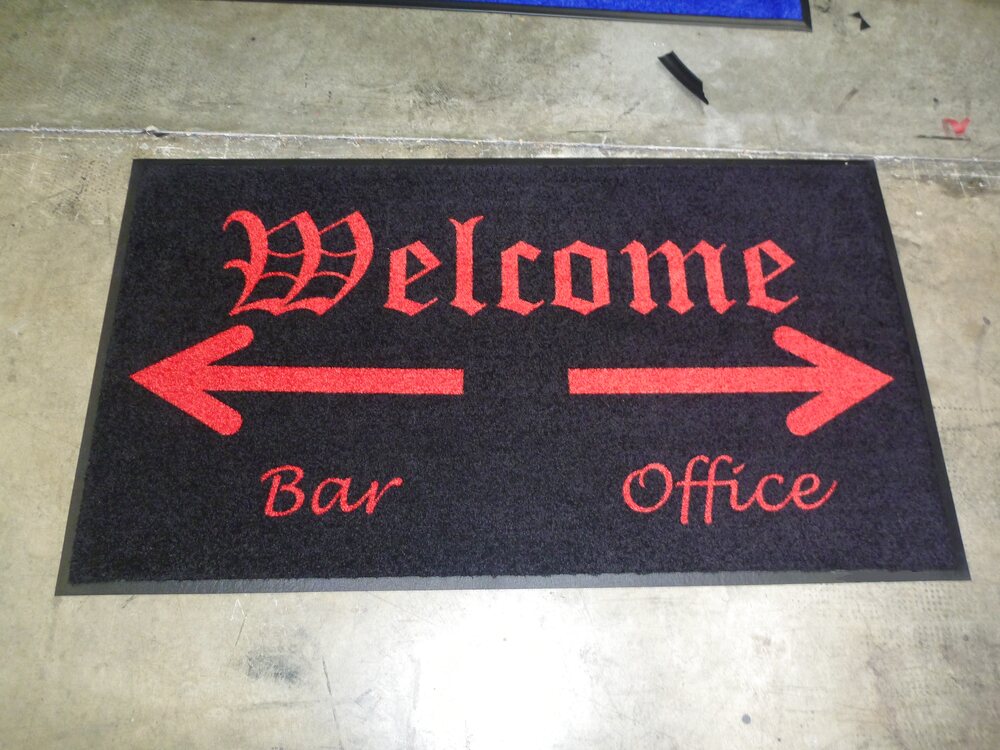 Black welcome mat with red arrows pointing to Bar and Office